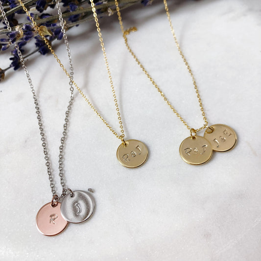 Mixed metal charms, hand-stamped discs on dainty chain. The background is a bundle of dried lavender and sage. Customized necklaces, stamped to your request with a quick turnaround time.
