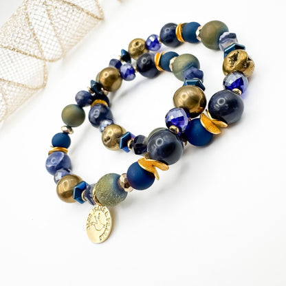 Between Stars Subdued Sparkle handmade bracelet pair featuring sodalite, gold and olive green geode druzy and electroplated hematite with faceted blue glass and brushed gold accents, gold Blue Jeans and Pearls charm, one of a kind moody gemstone jewelry Saskatchewan