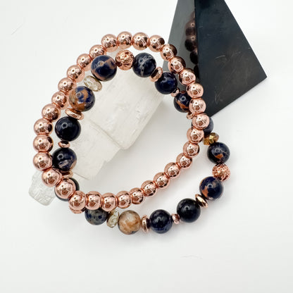 Brazilian sodalite and rose gold lava stone handmade bracelet pair showing two variations stacked on selenite crystal tower with black geometric display, intuition and calm gemstone jewelry by Blue Jeans and Pearls Saskatchewan