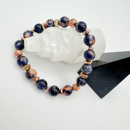 Brazilian sodalite handmade bracelet with rose gold electroplated lava stone beads and rose gold accents displayed on selenite crystal tower, intuition and calm healing jewelry by Blue Jeans and Pearls Saskatchewan