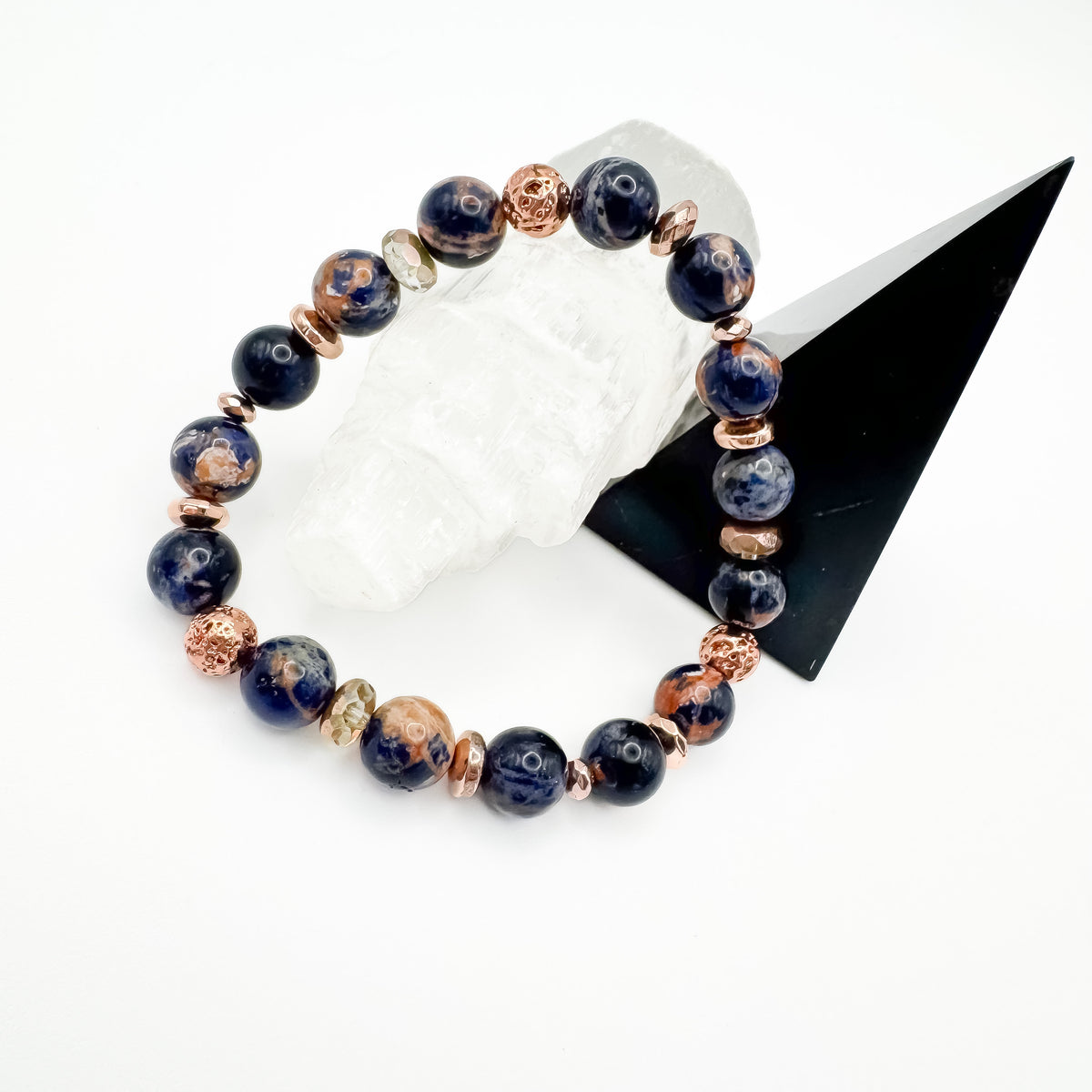 Brazilian sodalite and rose gold electroplated lava stone handmade bracelet with rose gold accents styled on white crystal and black geometric display, intuition and calm diffuser jewelry by Blue Jeans and Pearls Saskatchewan