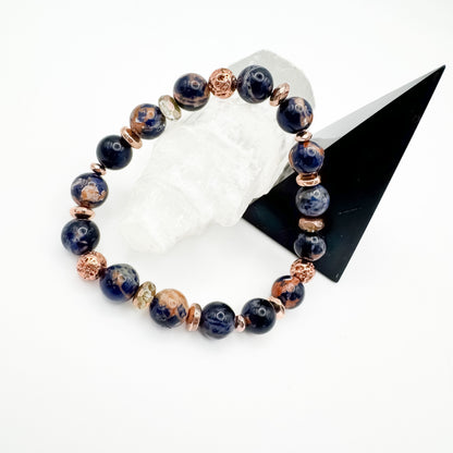 Brazilian sodalite and rose gold electroplated lava stone handmade bracelet with rose gold accents styled on white crystal and black geometric display, intuition and calm diffuser jewelry by Blue Jeans and Pearls Saskatchewan