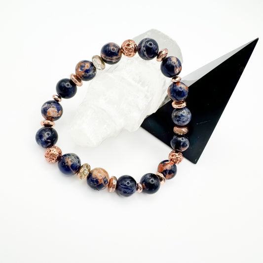 Brazilian sodalite and rose gold electroplated lava stone handmade bracelet with rose gold accents styled on white crystal and black geometric display, intuition and calm diffuser jewelry by Blue Jeans and Pearls Saskatchewan