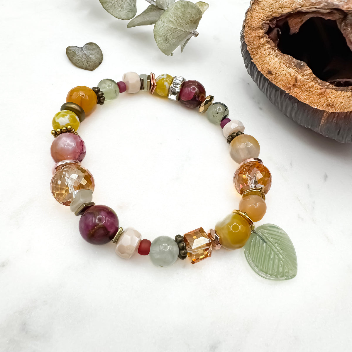 Prairie Sunsets Fuchsia and Firelight handmade prehnite, fire agate and mosaic stone bracelet with glass leaf charm and amber Austrian crystal cube on marble with eucalyptus, unique gemstone jewelry by Blue Jeans and Pearls Saskatchewan