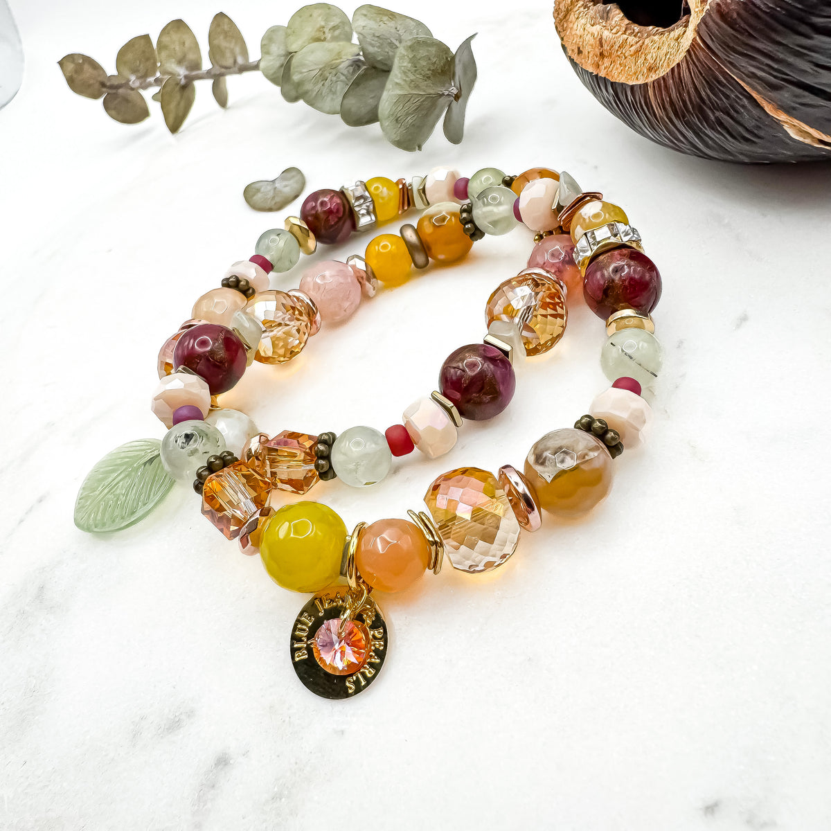 Prairie Sunsets Fuchsia and Firelight handmade fire agate and prehnite bracelet pair with glass leaf charm and gold Blue Jeans and Pearls charm on marble with eucalyptus, one of a kind prairie inspired jewelry Saskatchewan