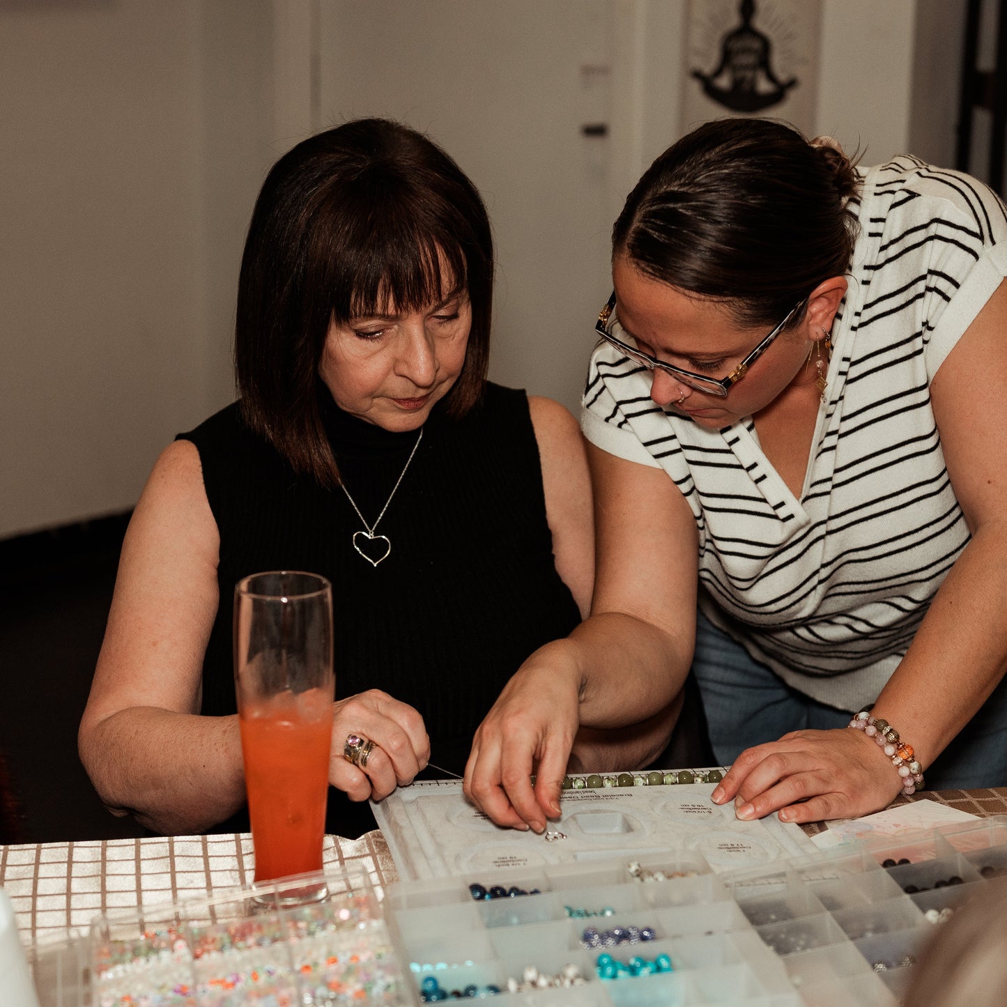 Megan guiding a workshop guest in bracelet making.