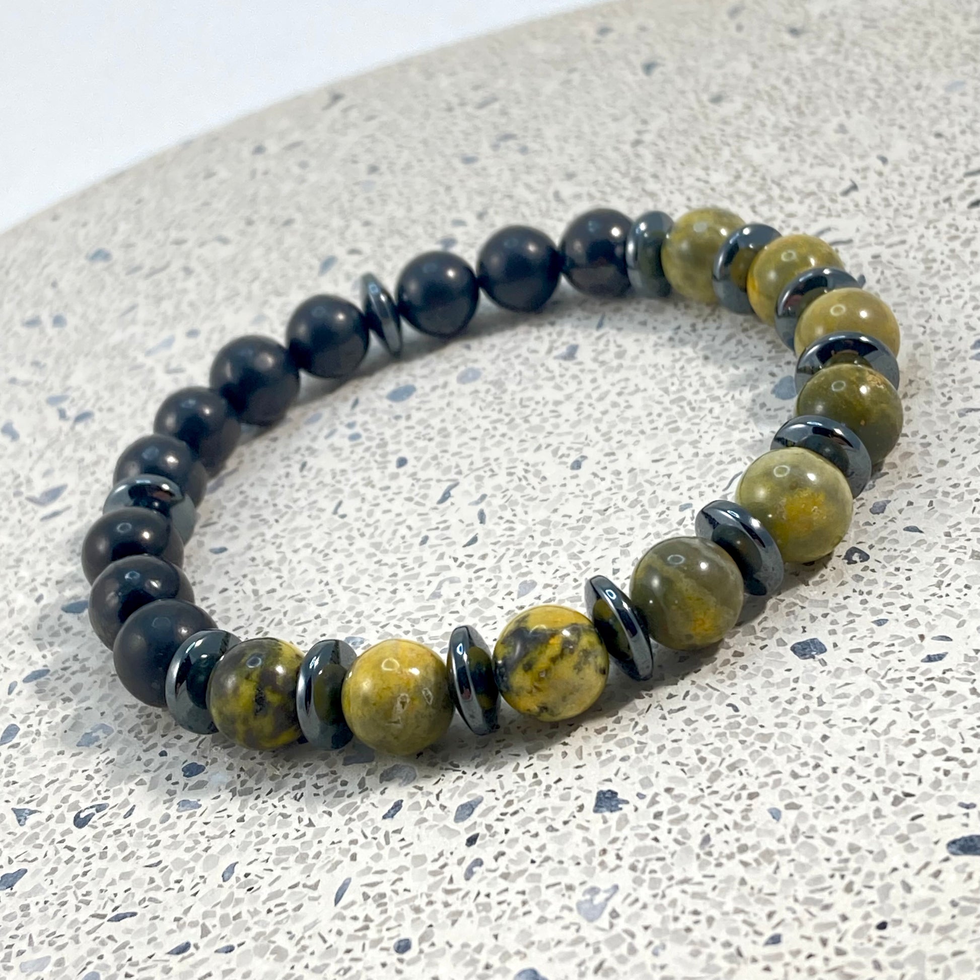 Men's Bumblebee Jasper, Shungite and Hematite handmade bracelet with matte black shungite beads, yellow bumblebee jasper and hematite saucer spacers on terrazzo, grounding men's gemstone jewelry handcrafted by Blue Jeans and Pearls Saskatchewan