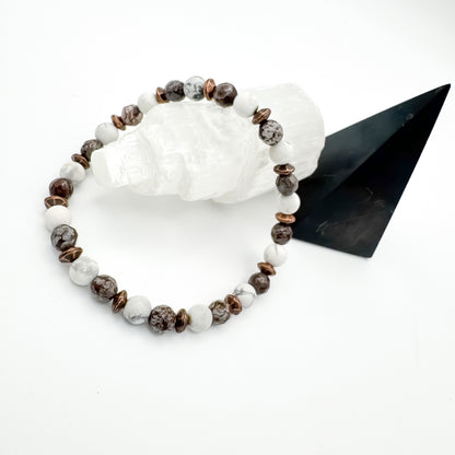 Men's Obsidian, Howlite and Copper handmade bracelet with faceted obsidian, white howlite beads and copper saucer spacers resting on raw selenite crystal beside black pyramid, grounding men's gemstone jewelry by Blue Jeans and Pearls Saskatchewan