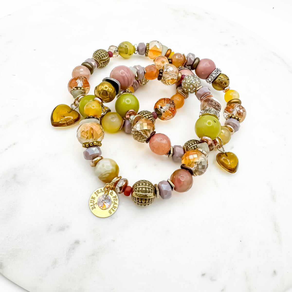Prairie Sunsets Lime and Lilac Skies handmade serpentine, prehnite and rhodochrosite bracelet triple stack with amber glass heart charms and gold Blue Jeans and Pearls charm on marble, one of a kind Canadian gemstone jewelry Saskatchewan