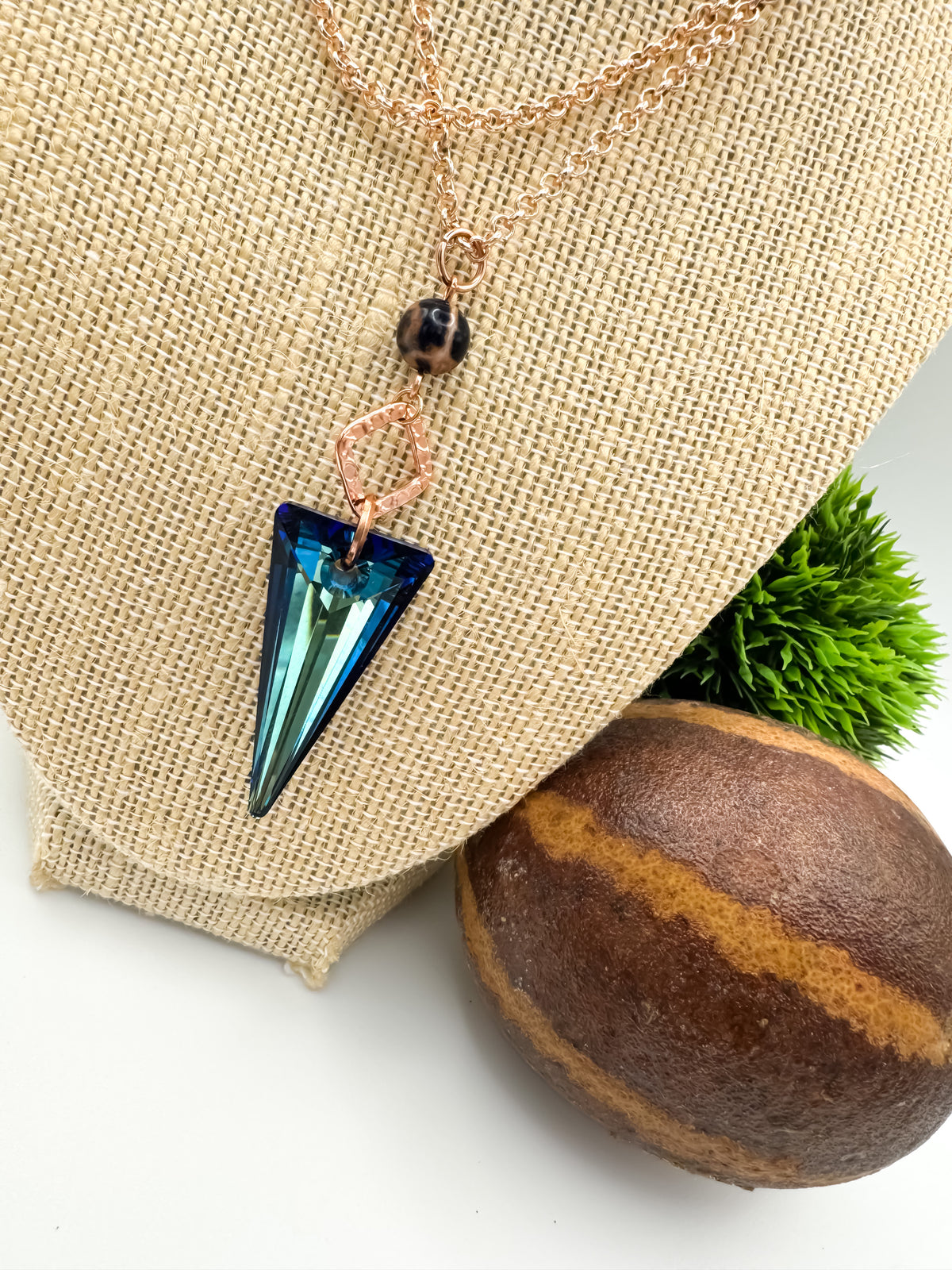 Seas and Sunsets Necklace on a burlap jewelry bust showing the size and drop of the 39mm Bermuda Blue crystal spike pendant with a Brazilian sodalite bead and rose gold square connector on a rose gold plated chain, by Blue Jeans and Pearls Saskatchewan