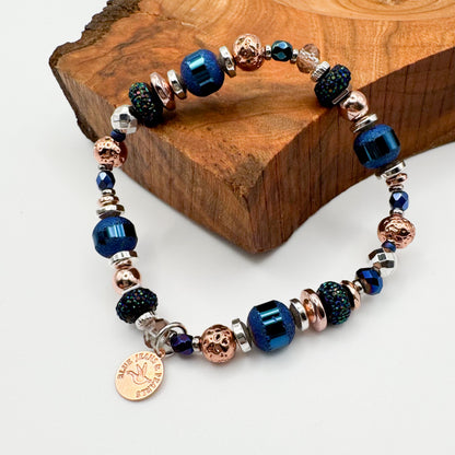 Silver Horizon handmade mixed metal bracelet featuring electroplated hematite, glitter resin and Czech glass beads with rose gold Blue Jeans and Pearls charm on natural wood slab, statement handmade jewelry Saskatchewan