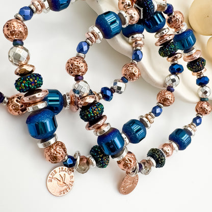 Close up detail of Silver Horizon handmade mixed metal bracelet stack with iridescent glitter resin, electroplated hematite and rose gold beads with Blue Jeans and Pearls charms, bold stackable jewelry Saskatchewan