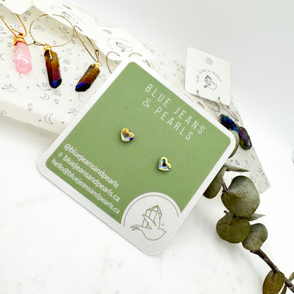 Small Heart Stud earrings in aurora borealis Austrian crystal on a sage green Blue Jeans and Pearls card, styled with aura crystal point hoop earrings and eucalyptus, metal-free studs for sensitive ears by Blue Jeans and Pearls Saskatchewan