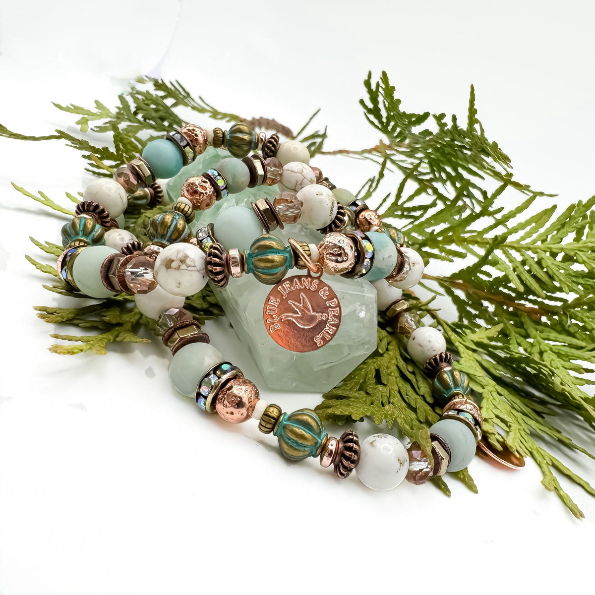Soft Horizons handmade amazonite and howlite bracelet stack with Blue Jeans and Pearls rose gold charm displayed on green fluorite crystal surrounded by cedar, one of a kind gemstone jewelry Saskatchewan