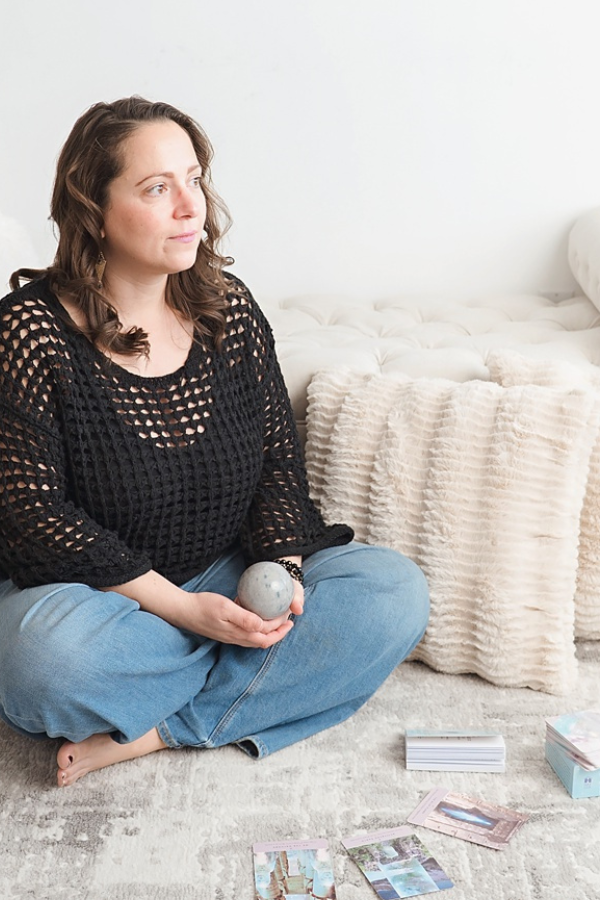 Megan, owner of Blue Jeans and Pearls Regina Saskatchewan, performing an angel card reading surrounded by crystals