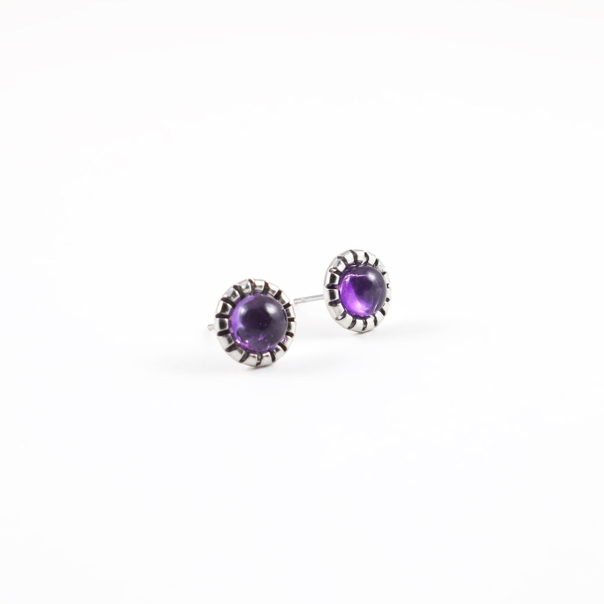 Amethyst stud earrings angled view showing stainless steel posts and 9mm round purple amethyst cabochons in scalloped bezel settings on white background, gemstone earrings for sensitive ears by Blue Jeans and Pearls Saskatchewan