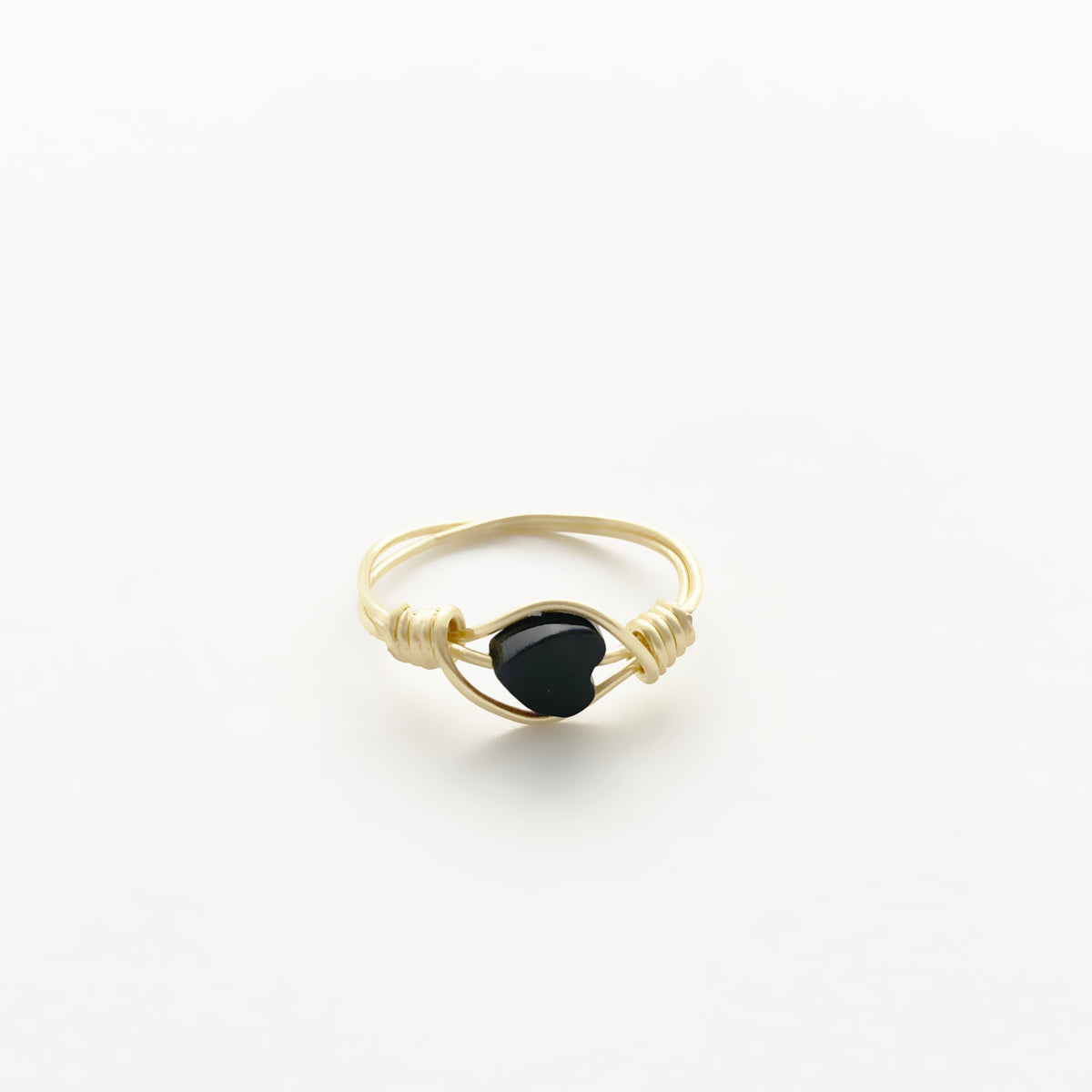 Black Onyx Heart wire-wrapped ring in gold finish copper wire with a polished black onyx heart bead framed by coiled wrap detail on a white background, handmade gemstone heart ring by Blue Jeans and Pearls Saskatchewan