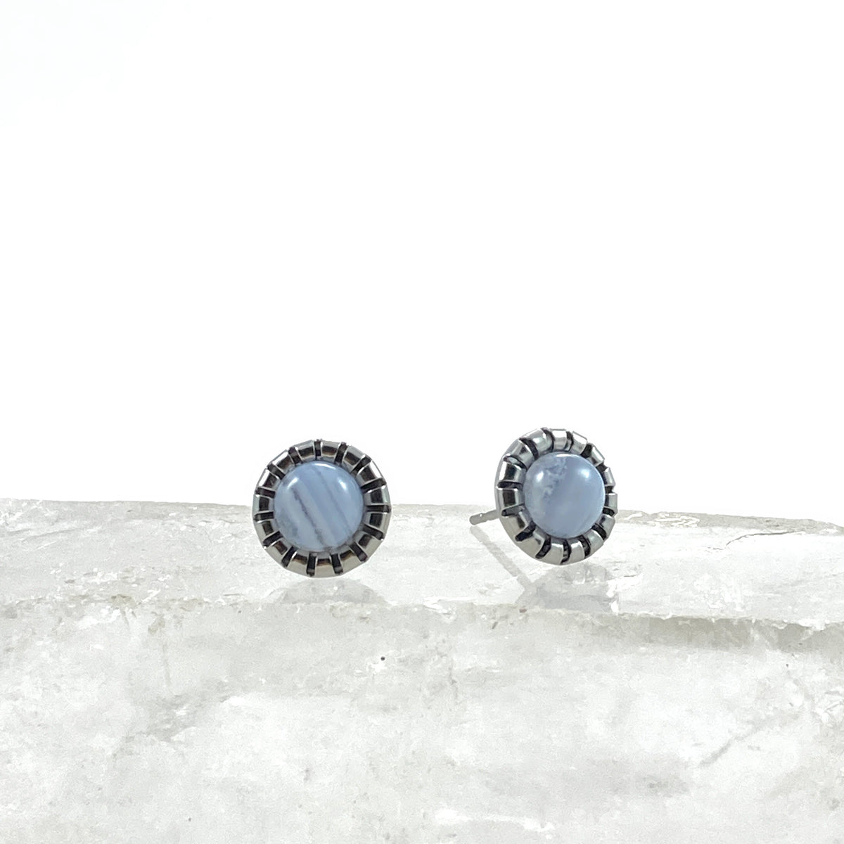 Blue Lace Agate stud earrings on raw white crystal showing unique natural banding in each 6mm pale blue agate cabochon, scalloped stainless steel bezel settings, calming gemstone earrings for sensitive ears by Blue Jeans and Pearls Saskatchewan