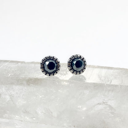 Faceted Hemalyke stud earrings front view on raw white crystal with 6mm mirror-like black gunmetal faceted stones in scalloped bezel settings, sleek black stud earrings by Blue Jeans and Pearls Saskatchewan