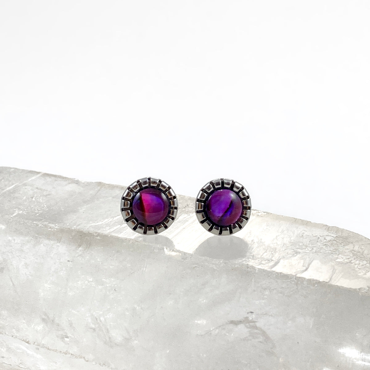 Magenta Paua Shell stud earrings on raw white crystal showing unique pink and violet swirls in each 6mm abalone shell, scalloped stainless steel bezel settings, iridescent stud earrings for sensitive ears by Blue Jeans and Pearls Saskatchewan