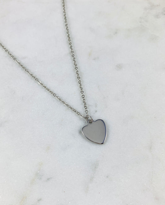 White Gold Heart Hand Stamped Initial Necklace with a polished 14k white gold plated heart pendant on a fine cable chain, shown blank before stamping on white marble, personalized necklace by Blue Jeans and Pearls Saskatchewan